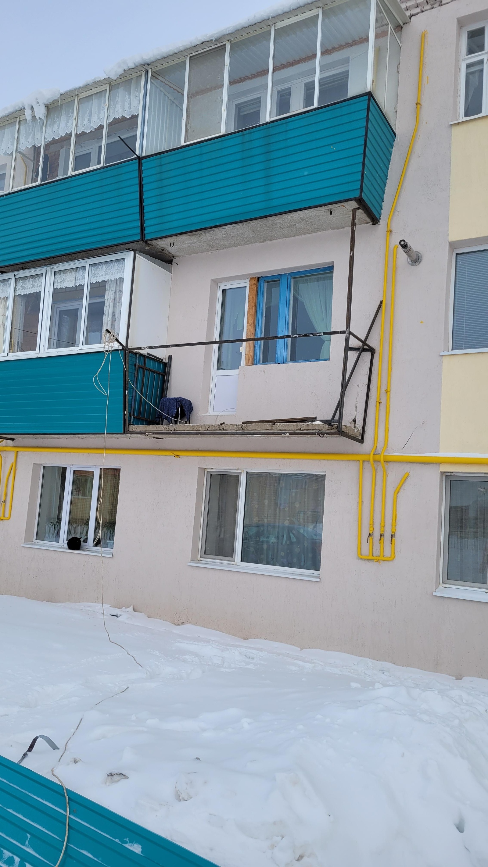 Остеклённый балкон с бирюзовой наружной отделкой.